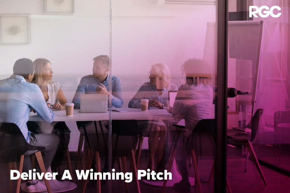 People around a table discussing matters and delivering a winning pitch